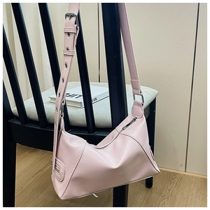 Pink lychee grain leather tote with adjustable silver eyelet strap on a chair
