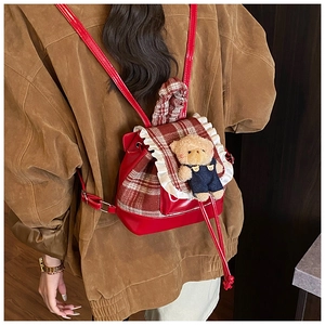Close-up of cute cartoon bear and lace trim on a red plaid toddler backpack back view