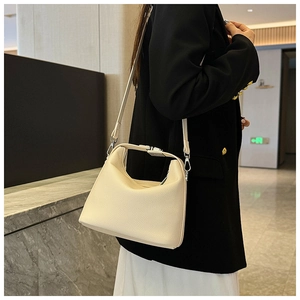 Detail der beigen Handtasche aus Leder mit Lychee-Muster und verstellbarem Riemen