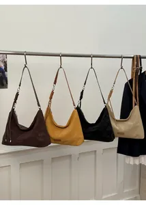 Detail of four hobo bags in brown, yellow, black, and beige suede with side knot accents