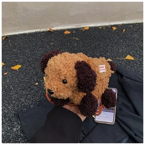 Détail d'un sac à bandoulière chiot en peluche avec fourrure bouclée et lanière en cuir