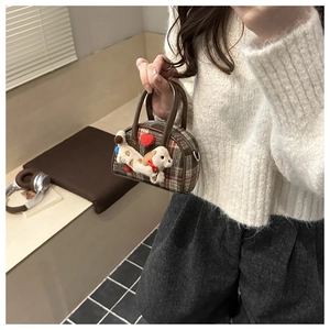 Détail du mini sac à main à carreaux avec chiot en peluche et motif de cœur rouge