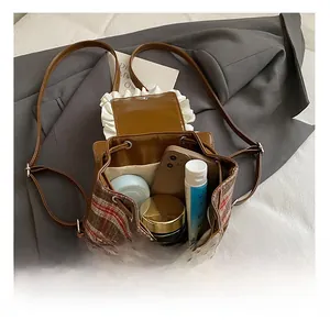 Detalle del interior de la mochila a cuadros marrones que muestra su gran capacidad