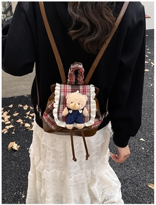 Detail of vintage bear toddler backpack featuring red plaid flap and lace trim