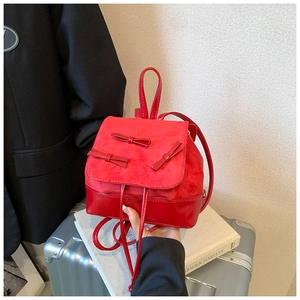 Detail of red mini backpack with 3D bows and suede-leather mix texture