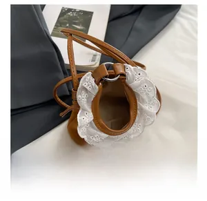 Vue détaillée d'un mini sac seau marron orné de dentelle blanche brodée élégante