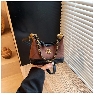 Detail of child quilted crossbody bag featuring brown suede and metal chain logo