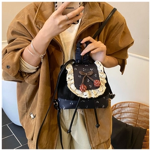Détails du sac à dos noir avec bordure en dentelle, breloque cerise et motif fleuri