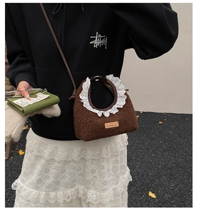 Detail of dark brown faux shearling bag with white lace trim and leather shoulder strap