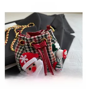 Vue détaillée du mini sac seau de Noël avec carreaux rouges et motifs 3D festifs