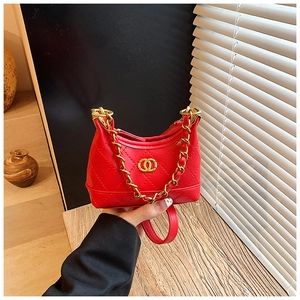 Detail of red quilted mini handbag featuring golden buckle and classic chain strap