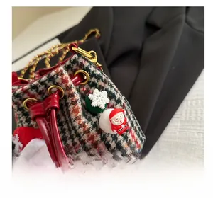 Detail of Christmas plaid mini bucket bag with plush Santa and golden chain strap