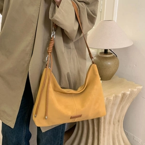 Minimalist yellow hobo shoulder bag with brown leather straps shown on a model