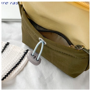 Detail of ripstop fabric kids bag featuring contrast colors and elastic drawstring buckle