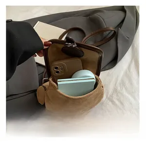 Interior capacity of brown suede bucket backpack showing phone and cosmetics