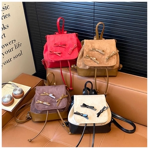Detail of stylish mini backpacks with bow accents and drawstring in four diverse colors