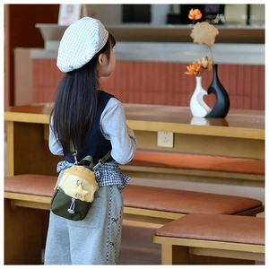 Detail of color-block kids crossbody bag with plush star pendant and white drawstring decor