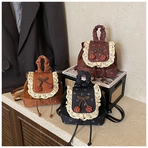 Vue détaillée de mini sacs à dos en toile vintage avec dentelle et décor cerise