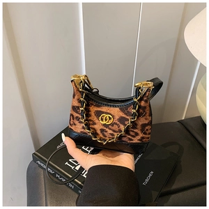 Detail of leopard print crescent bag with black quilted leather and gold chain