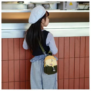 Close-up of kids contrast color nylon crossbody bag with yellow star charm on strap