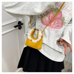 Détail du mini sac jaune en suédine avec dentelle blanche délicate et fine bandoulière