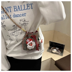 Detail of kids plaid bucket bag with Santa ornaments and gold chain strap in use