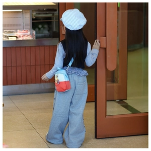 Kid's blue and orange color-block crossbody bag styled with a trendy casual outfit