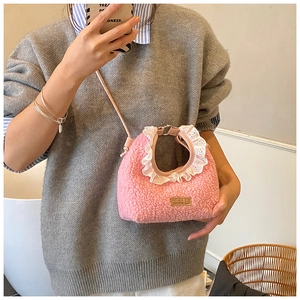 Close-up of pink plush teddy crossbody bag featuring white lace trim and leather strap