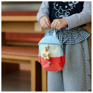 Detail of colorful kids canvas tote bag with a yellow plush star charm and blue handles
