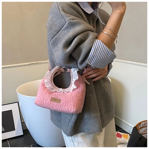 Close-up of pink plush handbag with white lace trim and Hand Made leather label