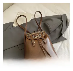 Dettaglio dello zaino in pelle marrone con patta leopardata e fibbia decorativa