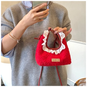 Detail of red plush kids handbag with white lace trim and small handmade logo patch