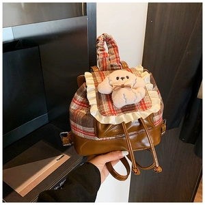 Detalle de mochila infantil de cuadros con perrito de peluche y adornos de volantes