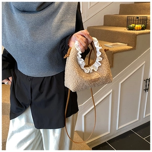 Detail of beige sherpa mini bag featuring white lace trim and slim brown leather strap