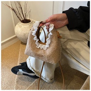 Close-up of faux shearling kids handbag with white lace trim and brown leather straps