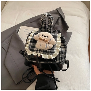 Detalle de mochila infantil de cuadros con peluche de perrito y ribete volado
