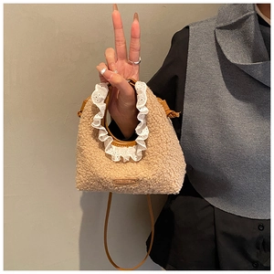 Close-up of khaki plush kids bag with white lace ruffle edge and leather strap detail