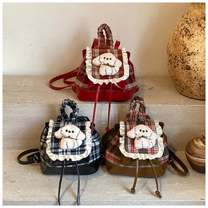 Vista de mochilas infantiles a cuadros con cachorros de peluche y detalles de volantes