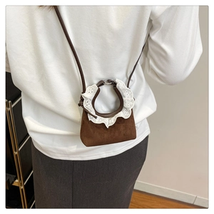 Mini sac en daim marron avec détails de dentelle blanche porté à l'épaule sur mannequin