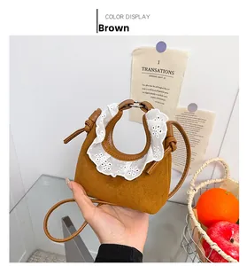 Detail einer braunen Wildleder-Mini-Tasche mit eleganten weißen Spitzen-Rüschenbesatz