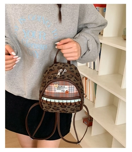 Stylish leopard print mini backpack with cute ruffle detail being held by a model