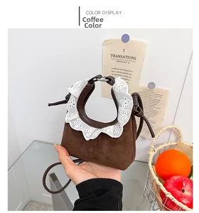Detail der kaffeebraunen Wildleder-Mini-Tasche mit weißem Spitzenbesatz und Schultergurt