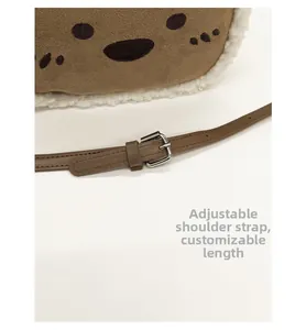 Detail of adjustable leather strap with silver buckle on plush brown crossbody bag