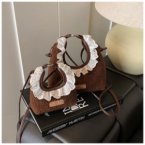 Close-up of brown plush handbag with white lace trim and handmade leather label detail