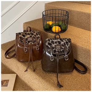 Dettaglio di mini zaini vintage con patte in pelliccia leopardata e cinturini in pelle