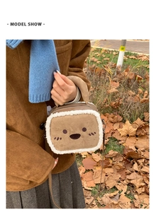 Detail of plush crossbody bag with suede texture and cute cartoon embroidery on autumn lawn
