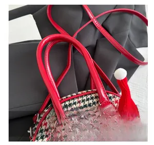 Gros plan détaillé du mini sac à main pied-de-poule avec poignée en cuir verni rouge
