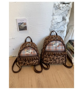 Two leopard print backpacks in different sizes shown in a lifestyle indoor setting