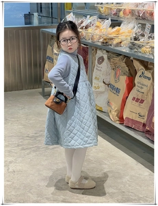 Détail d'une fille portant une robe matelassée bleu clair avec mini sac bandoulière