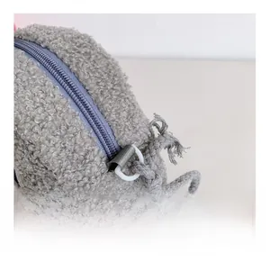 Detail der grauen Teddy-Fleece Kindertasche mit geflochtenem Seilriemen und Reißverschluss